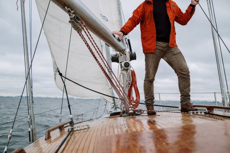 Man standing on a sailboat enjoying the journey with a vast horizon in the background