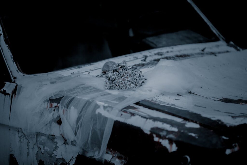 Photo of A Wreck Car With Veil and Flowers On Hood