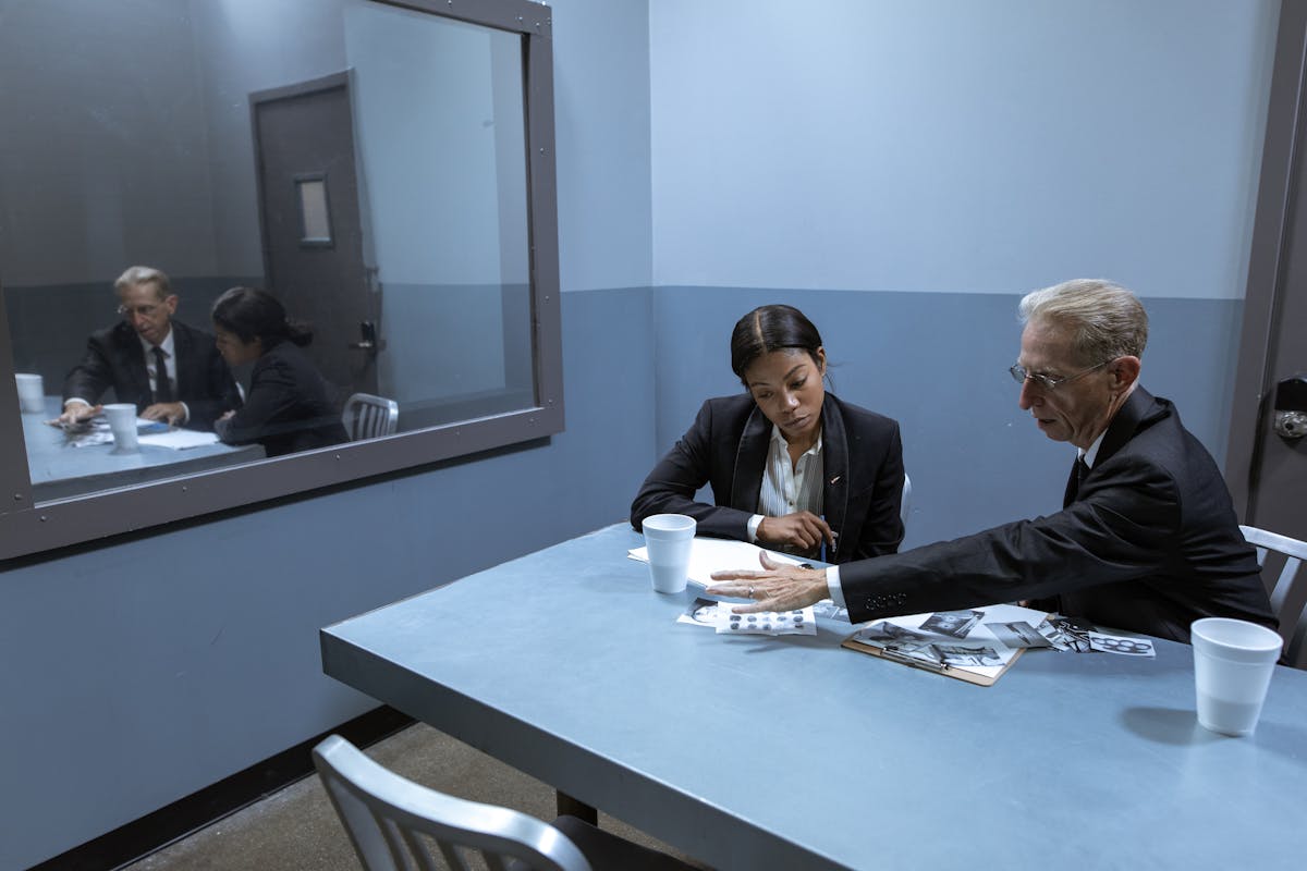 Man in Black Suit Jacket Sitting Beside Woman in Black Long Sleeve Shirt