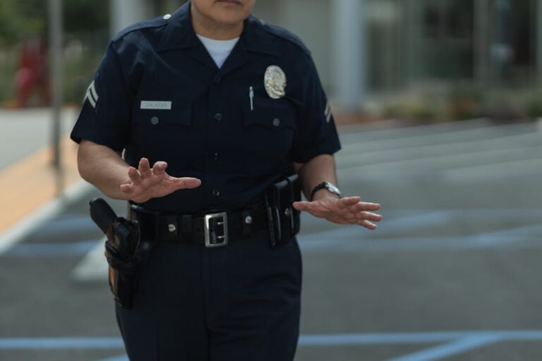 A police officer in uniform making gestures outdoors in a parking lot