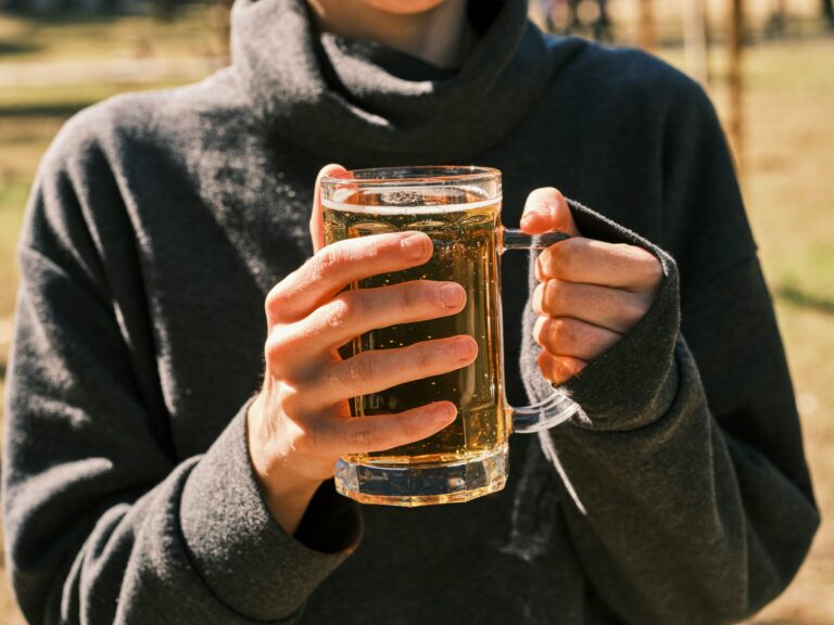 A woman holding a glass of beer in her hands photo